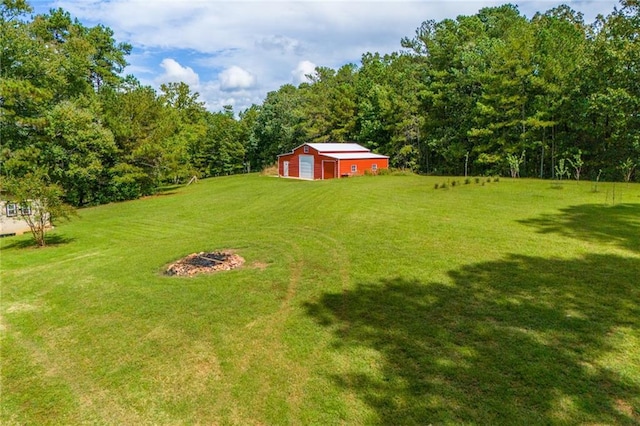 view of yard with a garage, an outbuilding, and a forest view