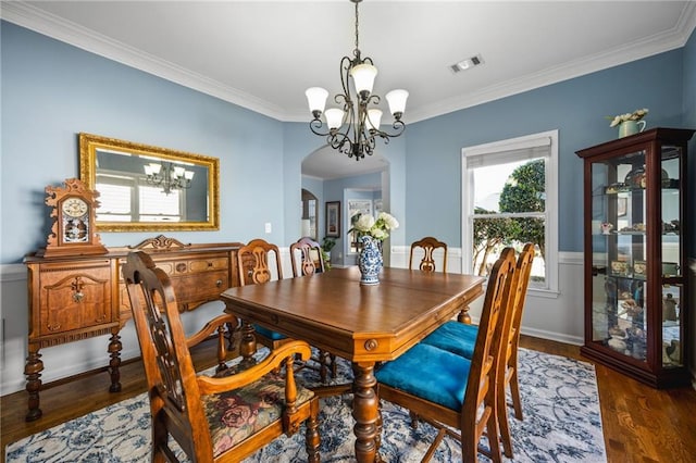 dining area with ornamental molding, dark hardwood / wood-style floors, and a notable chandelier