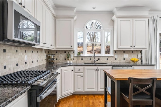 kitchen featuring appliances with stainless steel finishes, sink, and white cabinets