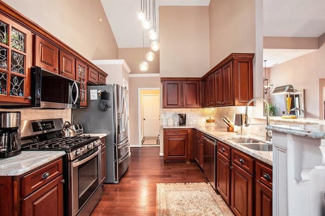 kitchen with sink, dark wood-type flooring, stainless steel appliances, high vaulted ceiling, and decorative backsplash