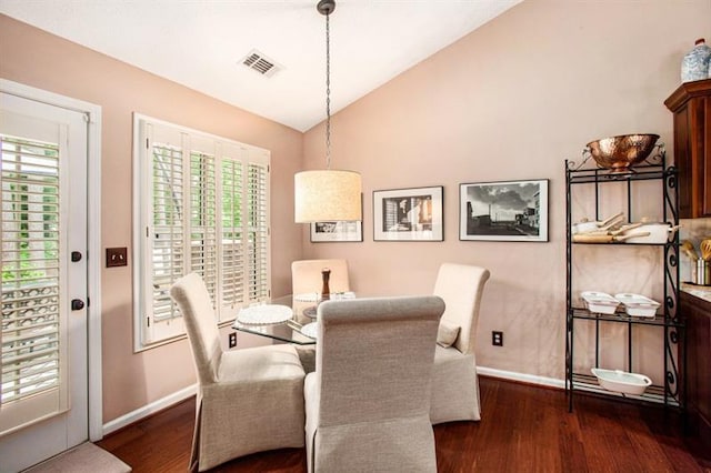 dining space with dark hardwood / wood-style floors and lofted ceiling