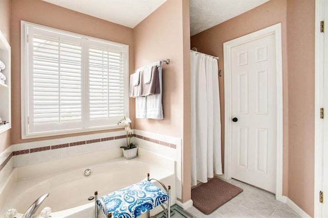 bathroom featuring a tub, tile patterned flooring, and a textured ceiling