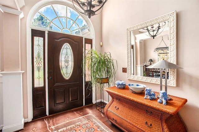 entryway with hardwood / wood-style floors and a notable chandelier