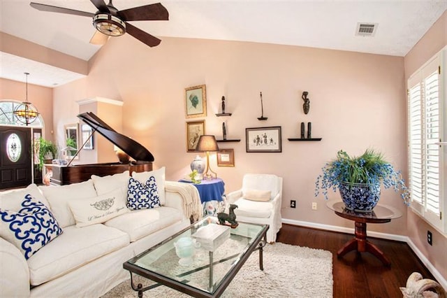 living room featuring dark hardwood / wood-style flooring, vaulted ceiling, and ceiling fan