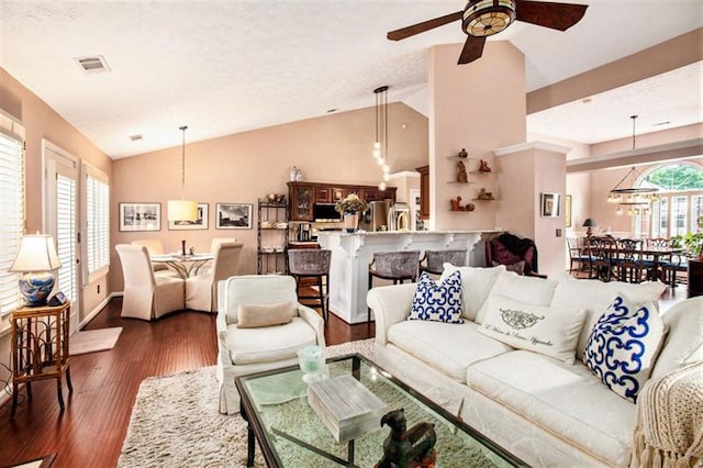 living room with dark hardwood / wood-style flooring, ceiling fan, and lofted ceiling