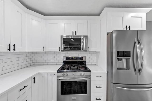 kitchen with white cabinetry, backsplash, and appliances with stainless steel finishes