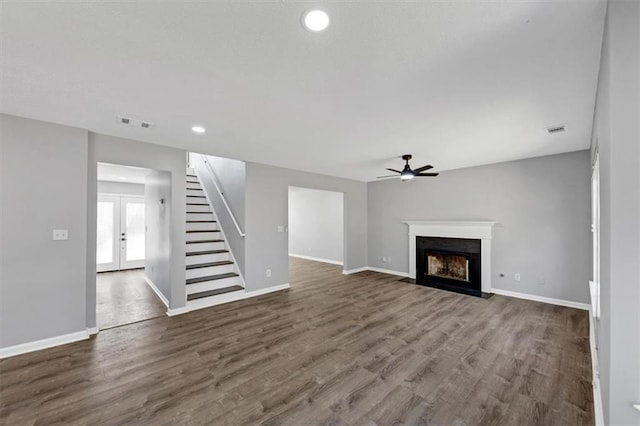 unfurnished living room featuring dark wood-type flooring, french doors, and ceiling fan