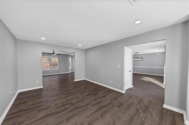 spare room featuring ceiling fan, dark hardwood / wood-style floors, and a textured ceiling