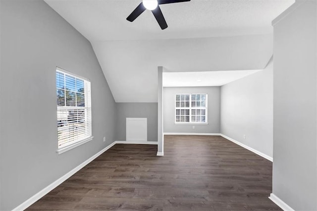 additional living space with lofted ceiling, dark wood-type flooring, and ceiling fan