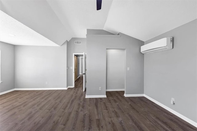 additional living space with ceiling fan, lofted ceiling, dark wood-type flooring, and a wall unit AC