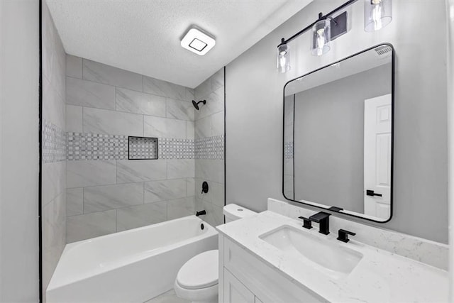 full bathroom featuring tiled shower / bath combo, vanity, a textured ceiling, and toilet