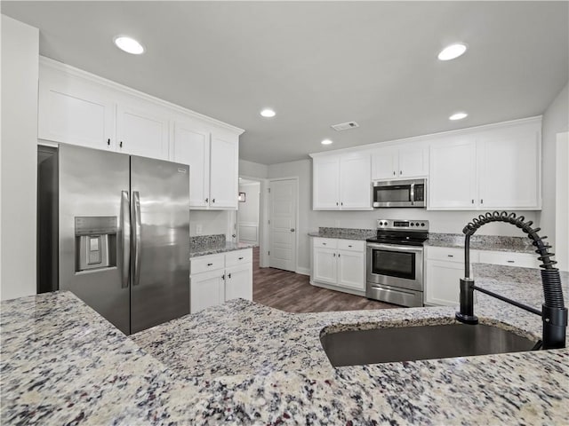 385 Finch Landing Rd, Winder, GA 30680 - kitchen featuring light stone countertops, white cabinetry, appliances with stainless steel finishes, a sink, and dark wood-style floors