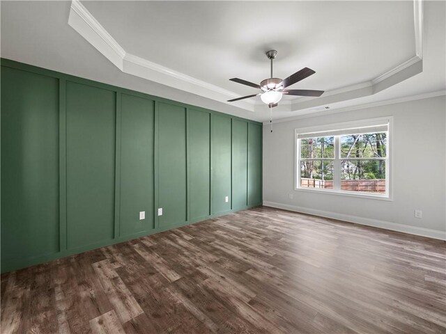 385 Finch Landing Rd, Winder, GA 30680 - spare room with crown molding, a ceiling fan, a tray ceiling, dark wood finished floors, and a decorative wall