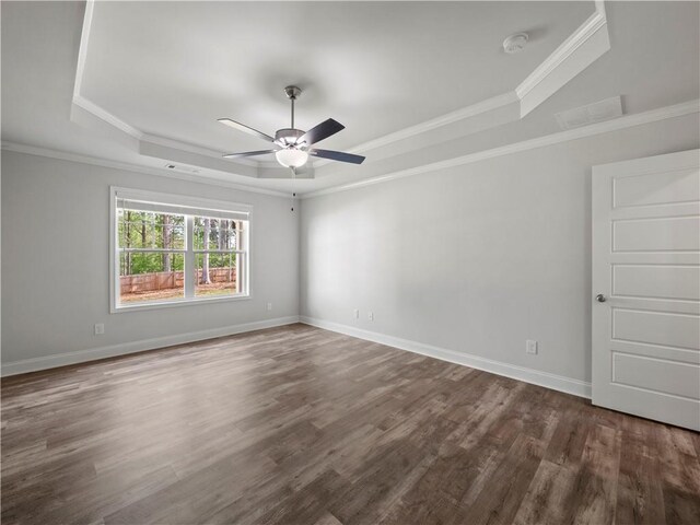 385 Finch Landing Rd, Winder, GA 30680 - empty room featuring a tray ceiling, dark wood-type flooring, ornamental molding, and a ceiling fan