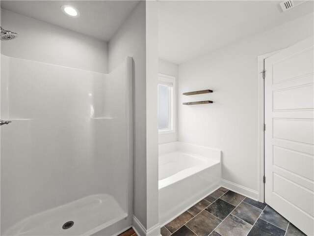 385 Finch Landing Rd, Winder, GA 30680 - full bath featuring visible vents, baseboards, stone finish floor, a stall shower, and a garden tub