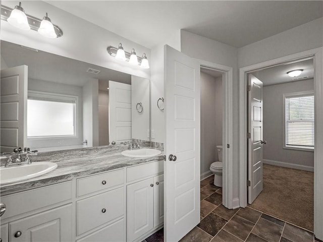 385 Finch Landing Rd, Winder, GA 30680 - bathroom featuring a sink, toilet, double vanity, and baseboards