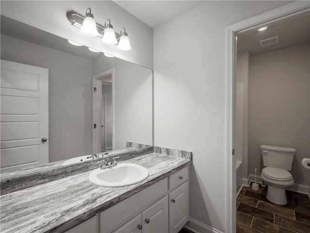 385 Finch Landing Rd, Winder, GA 30680 - bathroom featuring visible vents, baseboards, a bathing tub, toilet, and vanity