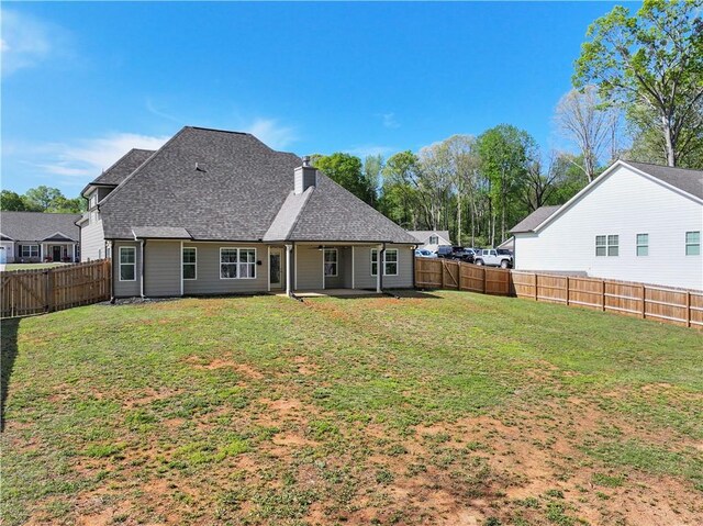 385 Finch Landing Rd, Winder, GA 30680 - rear view of house with a fenced backyard, a shingled roof, a lawn, and a chimney