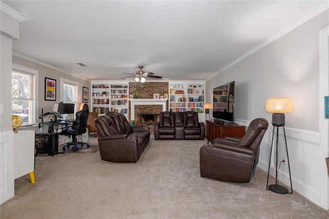 carpeted living area featuring crown molding, a brick fireplace, a ceiling fan, and built in features