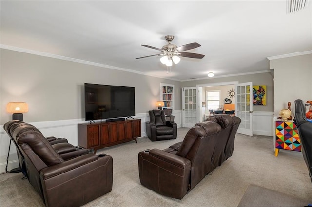 living area with french doors, light colored carpet, visible vents, ornamental molding, and ceiling fan