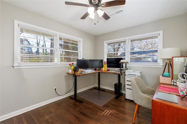 home office with a wealth of natural light, visible vents, baseboards, and wood finished floors