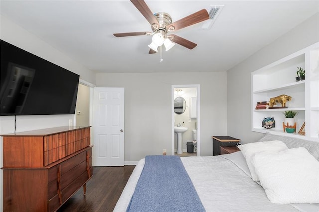 bedroom featuring dark wood-style flooring, visible vents, a sink, ensuite bath, and baseboards