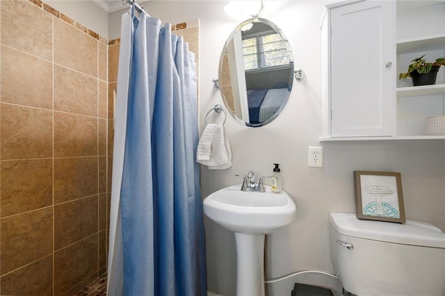 bathroom with a sink, a tile shower, and toilet