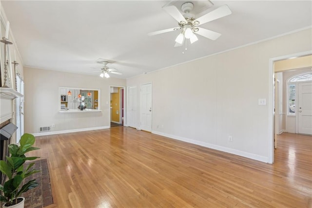 unfurnished living room with baseboards, visible vents, a ceiling fan, light wood-type flooring, and a brick fireplace