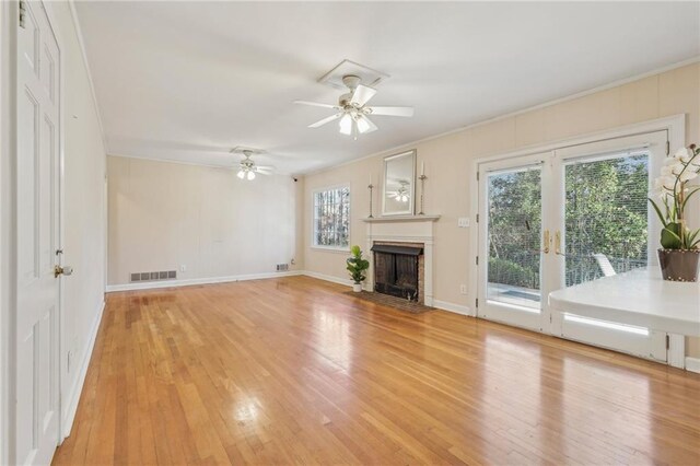 unfurnished living room with a fireplace with flush hearth, visible vents, light wood-style flooring, and baseboards