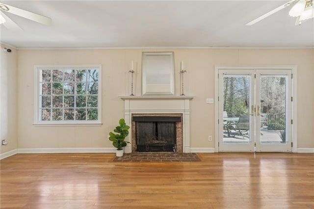 unfurnished living room featuring a healthy amount of sunlight, a ceiling fan, and wood finished floors