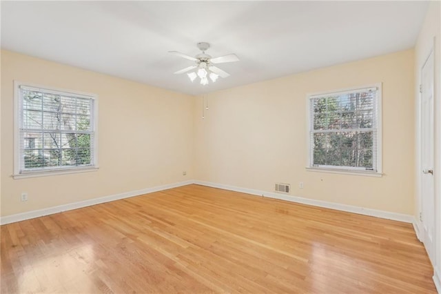 spare room featuring plenty of natural light, visible vents, and light wood-style flooring