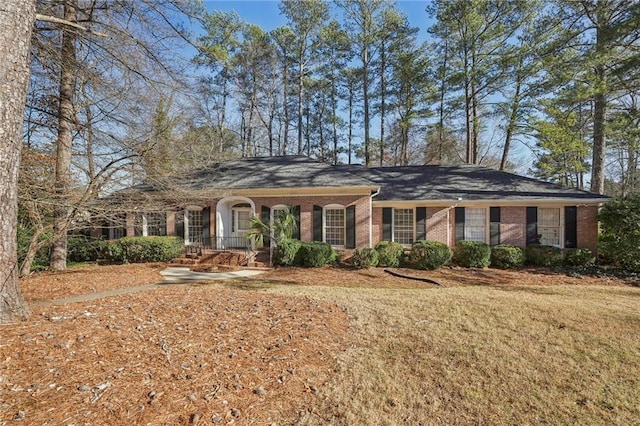 ranch-style home with a front yard and brick siding