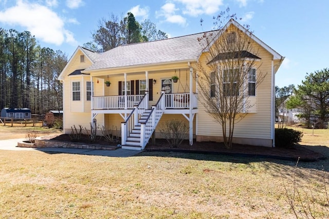 view of front of property with roof with shingles, stairs, a porch, and a front yard