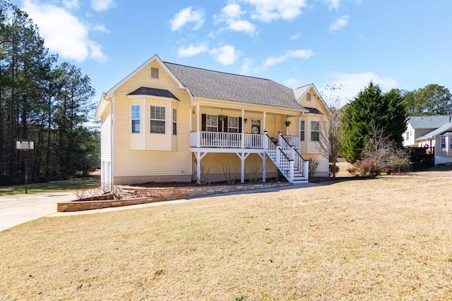 view of front of property with a porch, roof with shingles, a front lawn, and stairs