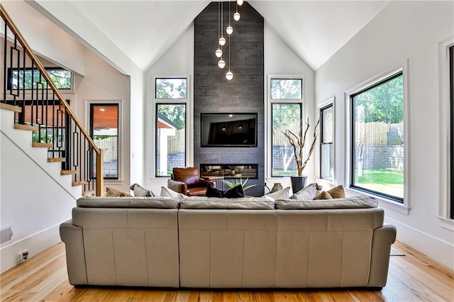 living room featuring a fireplace, vaulted ceiling, and light hardwood / wood-style flooring