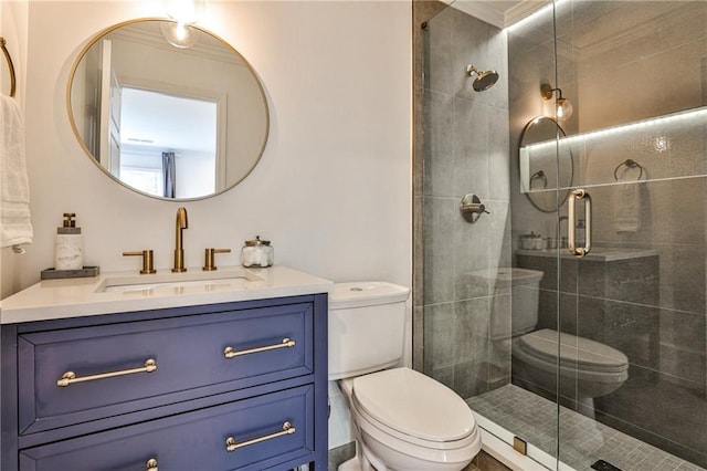 bathroom featuring toilet, crown molding, a shower with shower door, and vanity