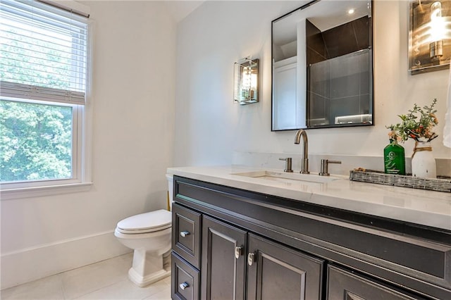 bathroom with toilet, vanity, tile patterned floors, and plenty of natural light