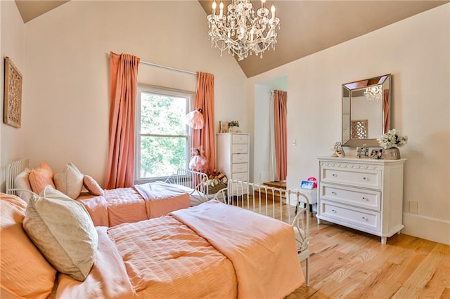 bedroom with a notable chandelier, light hardwood / wood-style flooring, and vaulted ceiling