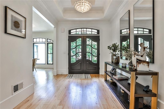 entryway featuring light wood-type flooring, an inviting chandelier, french doors, and a healthy amount of sunlight