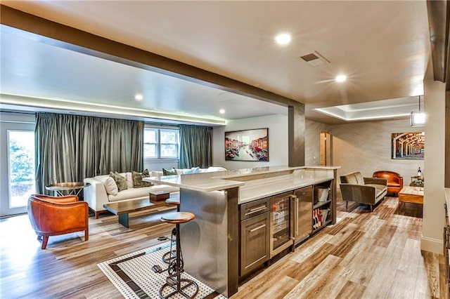 bar with light stone countertops, light wood-type flooring, and pendant lighting