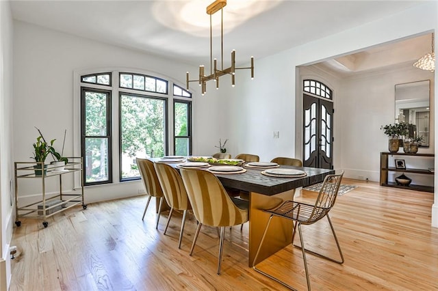 dining space with french doors and light hardwood / wood-style flooring