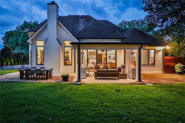 rear view of property featuring a patio area, a lawn, and an outdoor living space