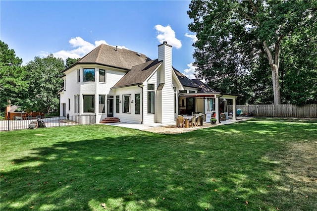 back of property with a patio and a lawn