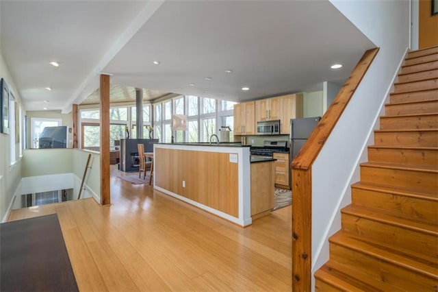 kitchen with light brown cabinetry, recessed lighting, baseboards, light wood-style floors, and stainless steel appliances