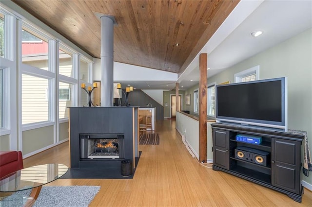 living room featuring a multi sided fireplace, wood ceiling, wood finished floors, and baseboards