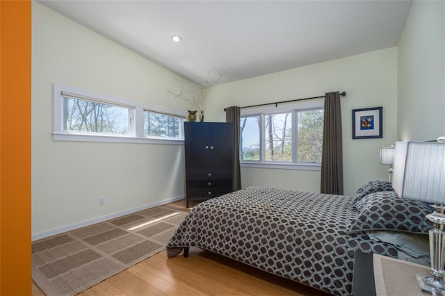 bedroom with wood finished floors, baseboards, and recessed lighting