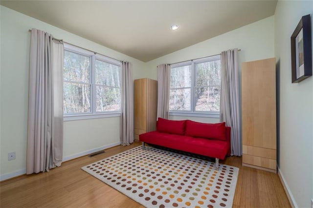 living area with wood finished floors, baseboards, and a healthy amount of sunlight