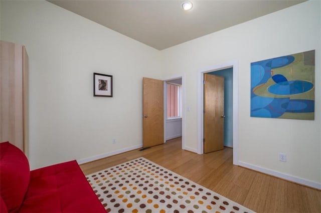 bedroom with wood finished floors and baseboards