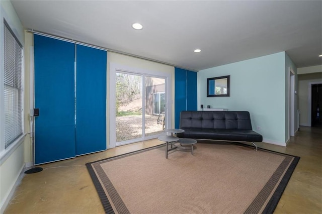 sitting room with concrete flooring, baseboards, and recessed lighting