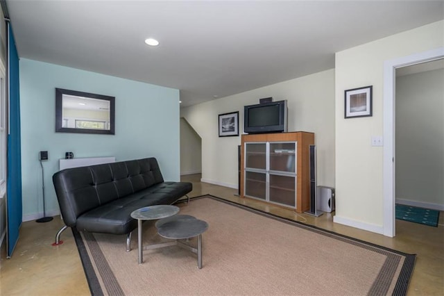 living area with baseboards, concrete floors, and recessed lighting